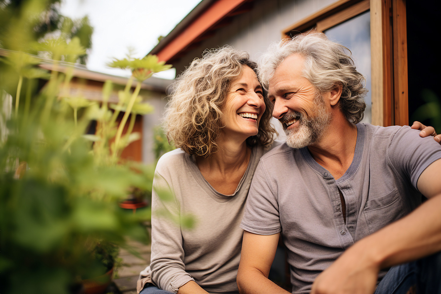 retired couple smiling outside house